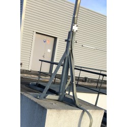 Lightning rod mast tripod fixed on concrete pedestal.